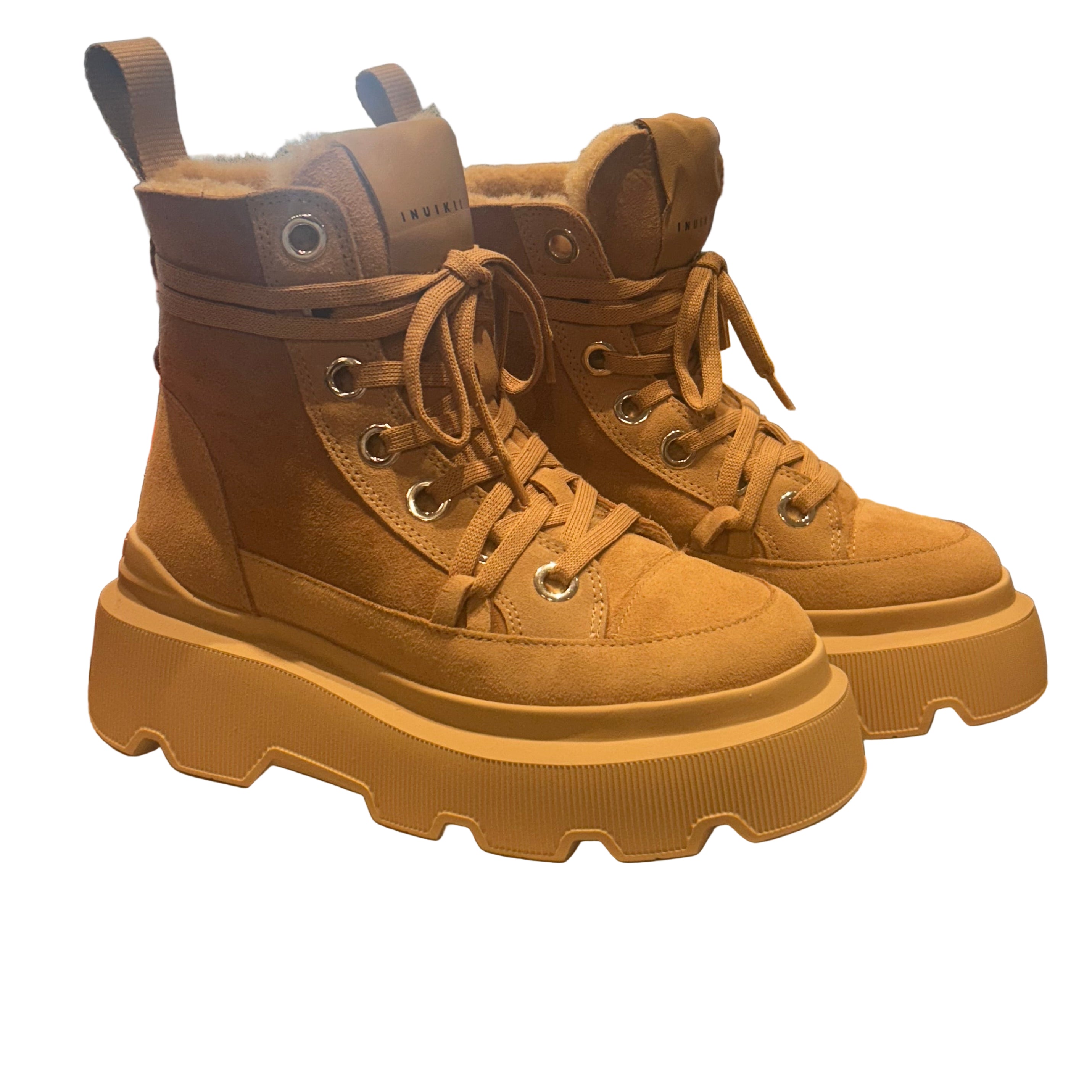 Pair of brown platform boots on a white background